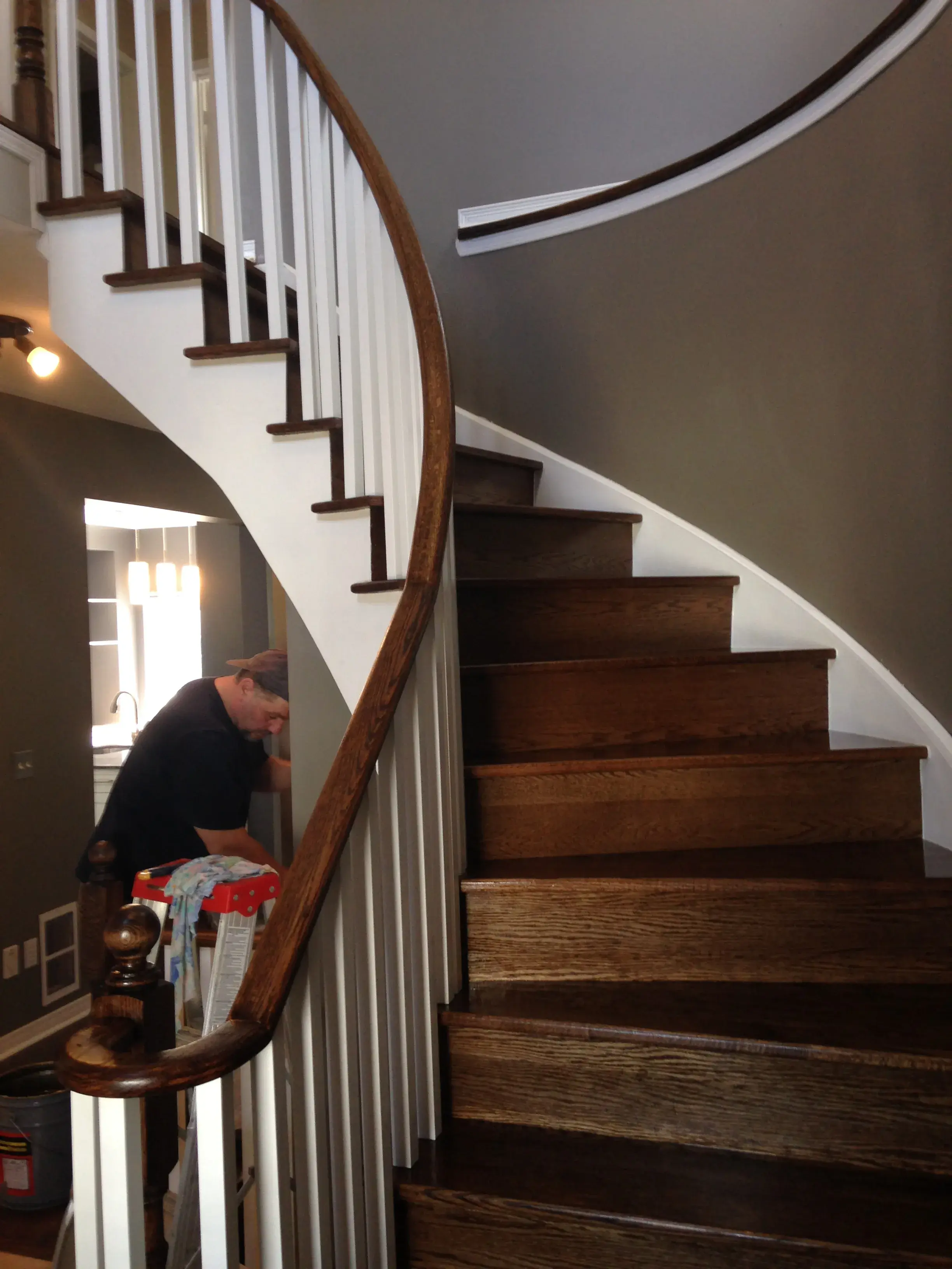 Curved staircase with dark-stained oak treads and white risers