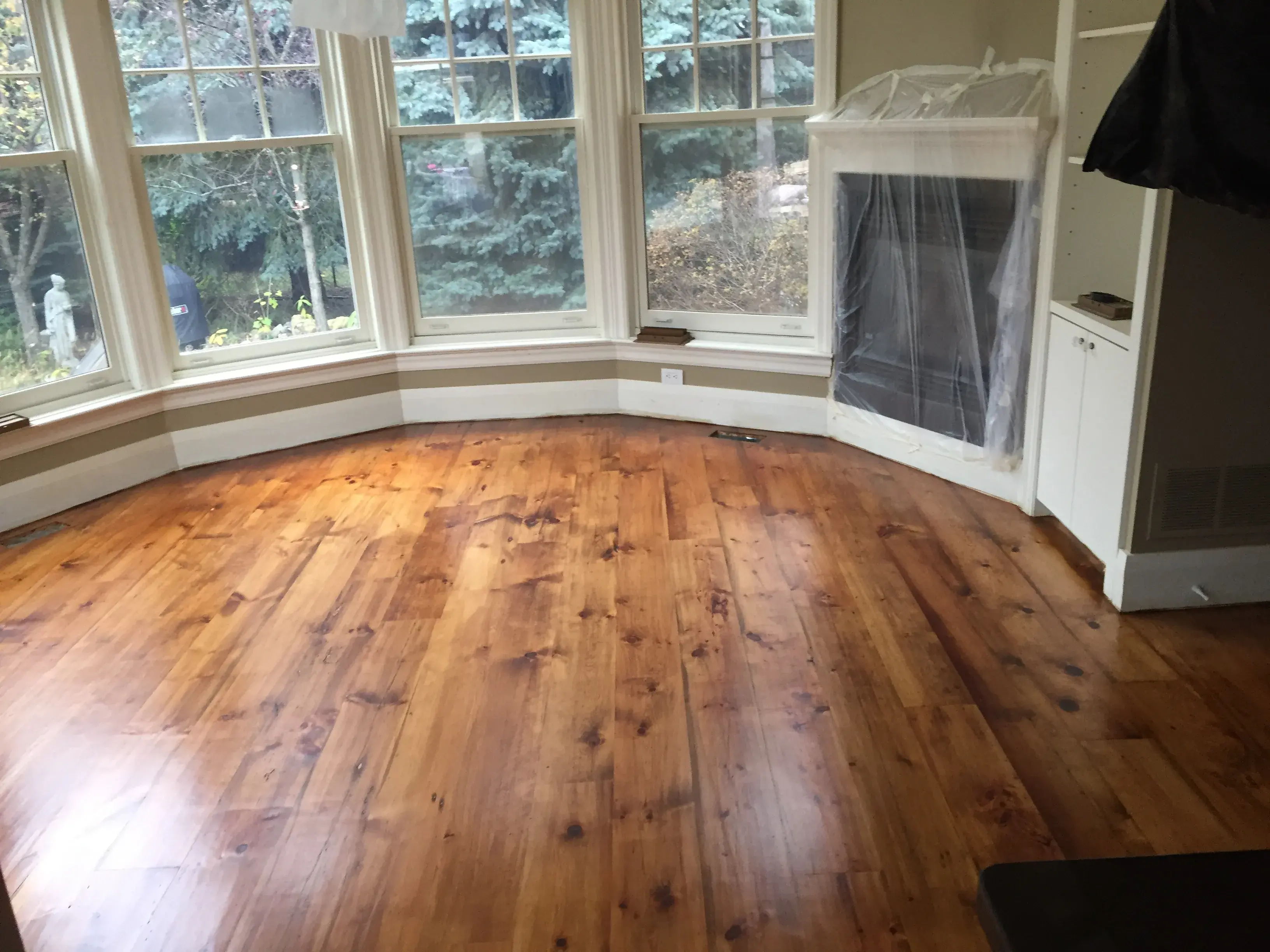 Warm hardwood floor in a bright bay-window room